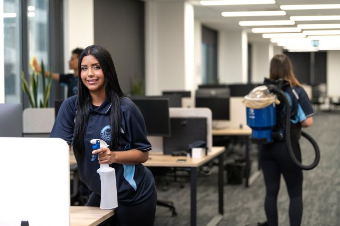 Smiling commercial cleaner ensuring customer satisfaction at Sydney office