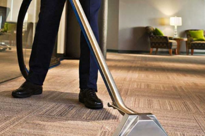 Technician using carpet cleaning machine in a Sydney office environment
